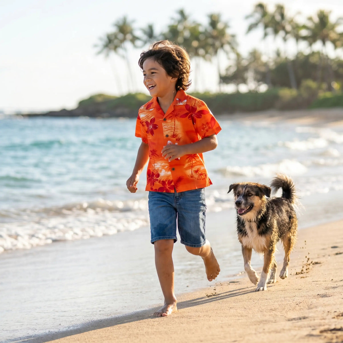 A boy in a vibrant orange hawaiian shirt with red floral patterns and blue denim shorts running barefoot on the beach.
