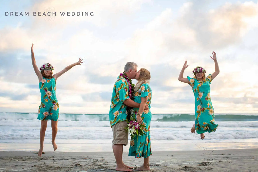 The couple wears matching turquoise hawaiian shirts with a vibrant floral pattern.