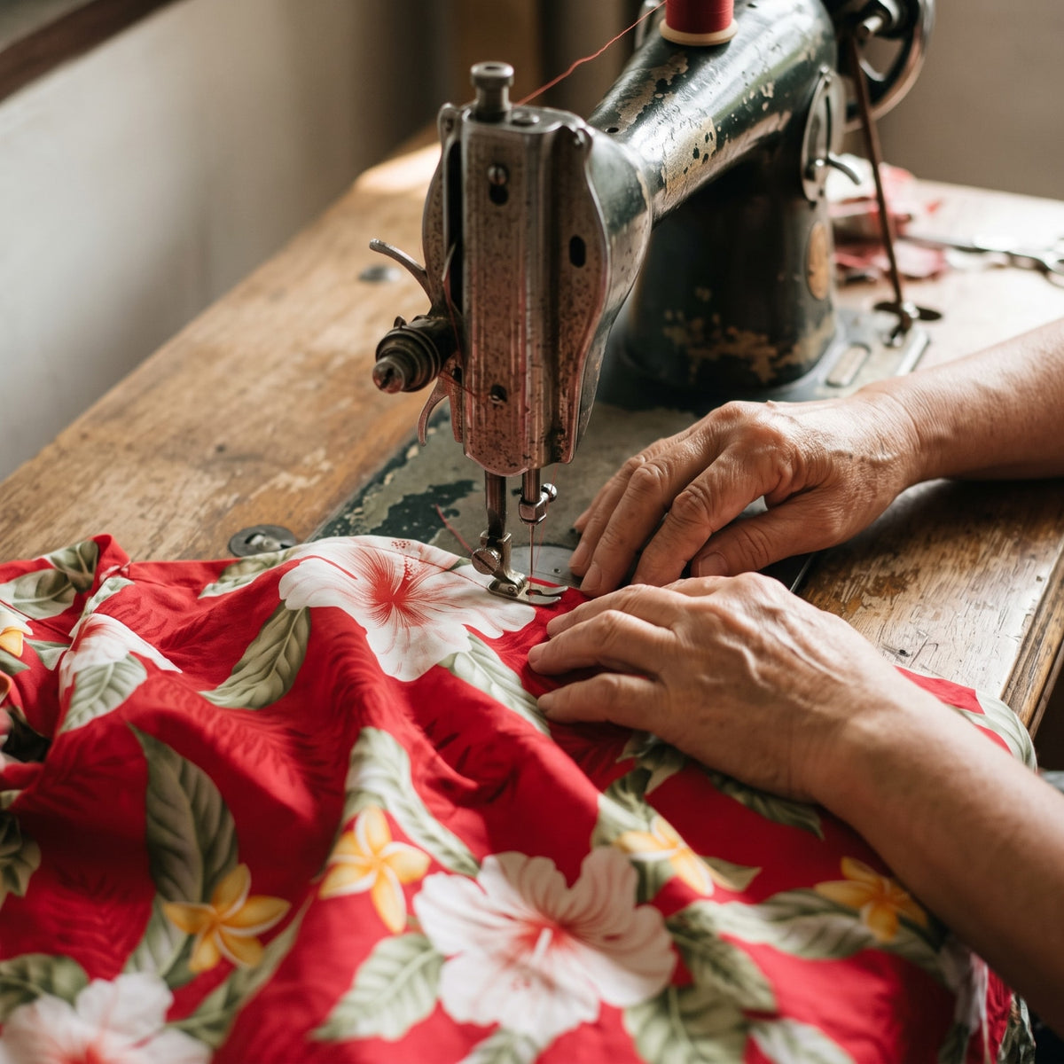 Artisan sewing authentic Hawaiian aloha shirt on sewing machine in Honolulu workshop