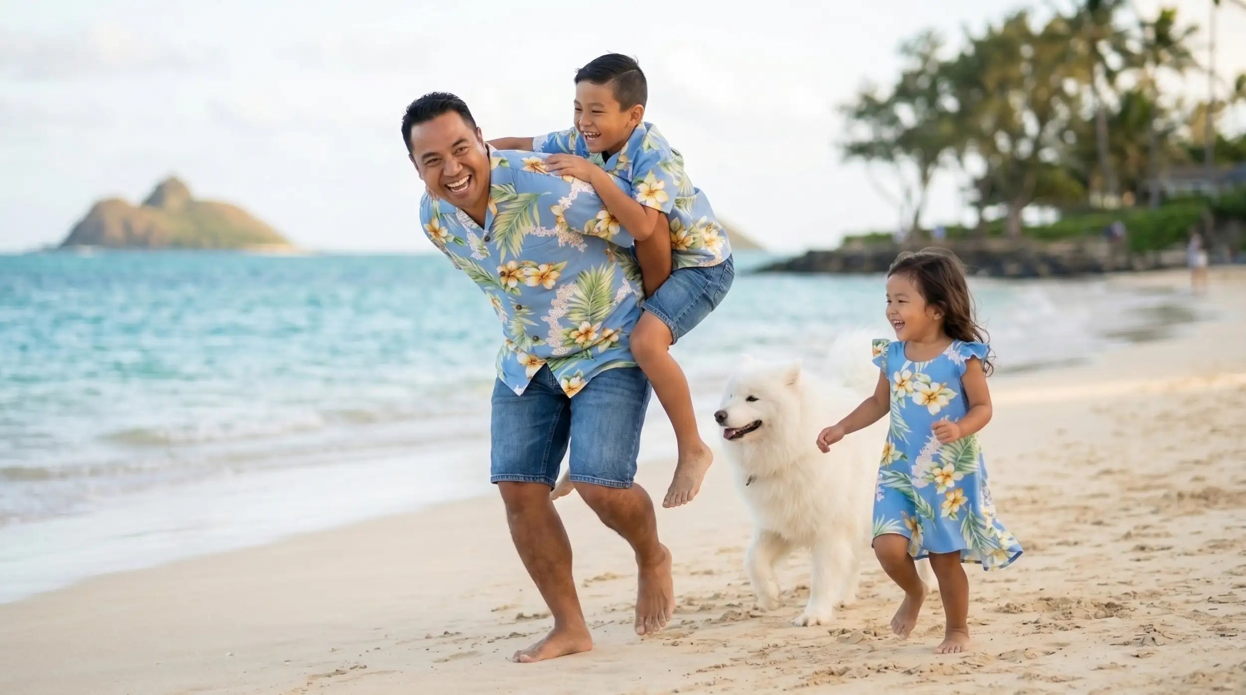 A man wearing a blue hawaiian shirt with yellow and white floral patterns, paired with denim shorts.