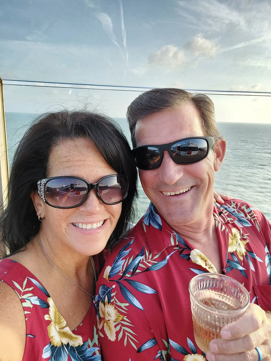 The man is wearing a red hawaiian shirt with blue and yellow floral patterns.